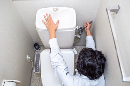 トイレの修理をする業者の男性